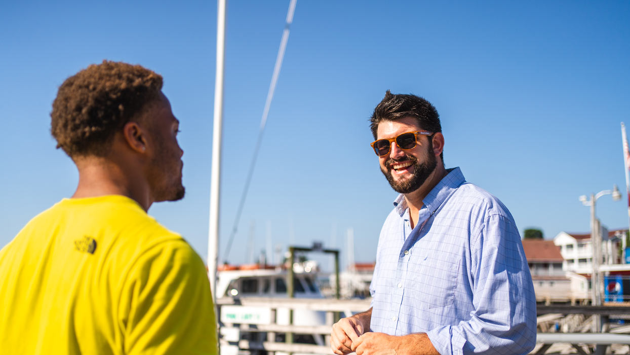 Tyler Tibbetts of William Raveis Luxury Properties talks with a client in Booth Bay Harbor, Maine.
